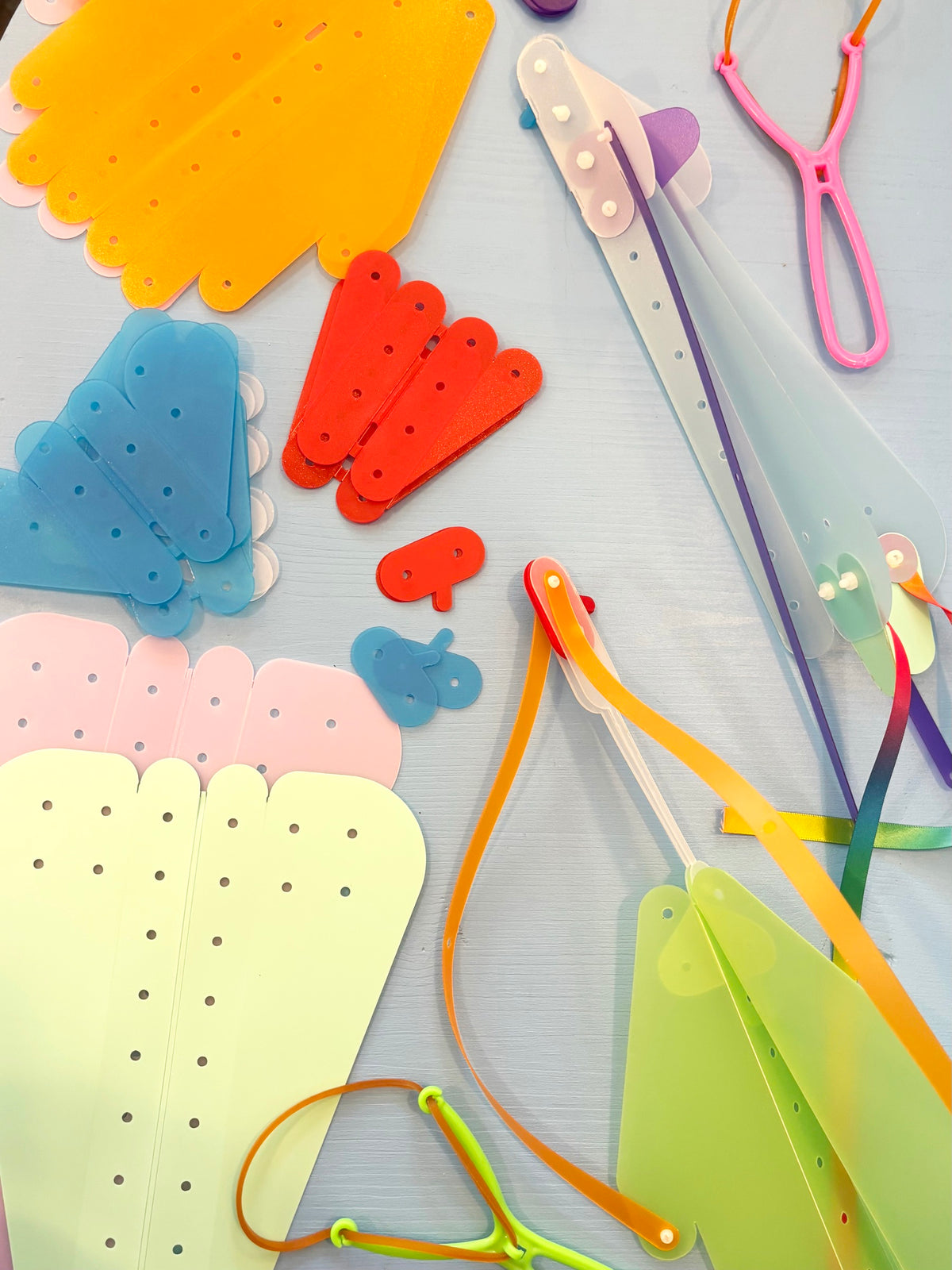 Atelier Fabrique ton avion : gabarits d’ailes et d’hélices en plastique coloré, élastiques et pièces à assembler